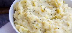 a white bowl filled with mashed potatoes on top of a table