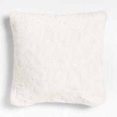 a white pillow with fluffy fur on the front and back of it, against a white background