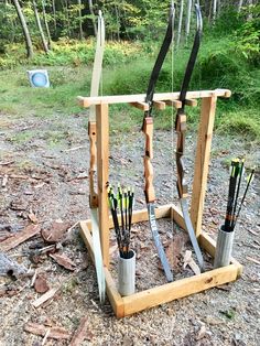 an archery set up on the ground with arrows in it and two buckets full of bows