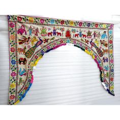 an arch made out of fabric with animals and flowers on it