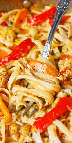 a pan filled with pasta and vegetables being stirred with a fork by a spatula