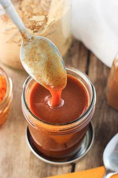 a spoon full of chocolate pudding on top of a wooden table