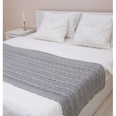 a bed with white pillows and blankets on it