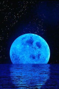 the full moon is shining bright blue in the night sky over water with stars above it