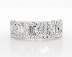 a wedding band with baguetts and diamonds on the side, set in 18k white gold