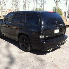 the black suv is parked on the side of the road