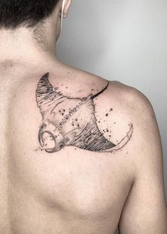 the back of a man's shoulder with a tattoo of a fish on it