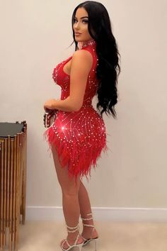 a woman in a red dress standing next to a table with a phone on it