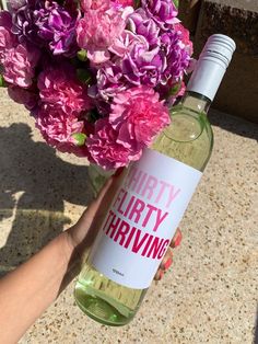 a person holding a wine bottle with flowers in it