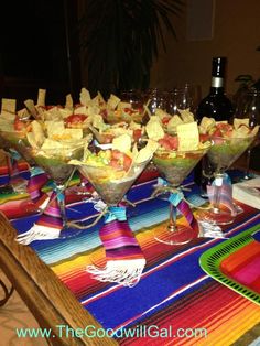 a table topped with glasses filled with different types of food