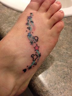 a person with a tattoo on their foot is standing in front of a white sink