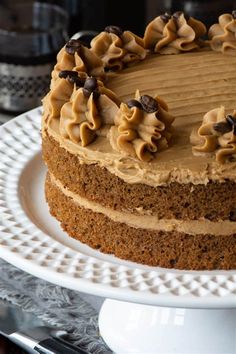 a cake with frosting and chocolate chips on top sitting on a white platter