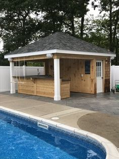 an outdoor kitchen next to a pool with a hot tub in the middle and a bar on the side