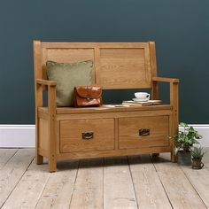 a wooden bench sitting on top of a hard wood floor next to a potted plant