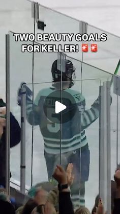 a hockey player is standing in front of an ice rink with his hands up to the crowd