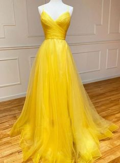 Seek the spotlight in this stunning yellow prom dress, designed to make a memorable impression. The dress features a sophisticated sweetheart neckline with delicate spaghetti straps that add a touch of elegance. The bodice is expertly ruched to enhance your natural shape, cinching at the waist to create a flattering silhouette. The skirt flows into a full-length A-line design, made from layers of soft tulle that create a graceful and fluid movement. The vibrant yellow color is both striking and cheerful, ensuring you stand out in any crowd. The back of the dress features a seamless zipper closure, providing both style and comfort. Ideal for prom, weddings, or any special occasion, this dress will make you feel confident, beautiful, and ready to shine. Prom Dress Yellow, Yellow Formal Dress, Princess Clothes, Tulle Long Prom Dress, Tulle Balls, Prom Dresses Yellow, Spaghetti Strap Prom Dress, Tulle Evening Dress, Long Prom Dresses