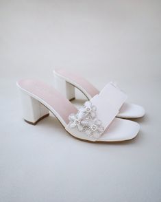 Classic satin slip on block heel sandals with the sparkly combination of pearls and rhinestones flowers adds an elegant sparkle for casual and dressy look. Simple and easy wear for bridal wear, bridesmaids, holiday party, wedding parties, and any special occasions. DETAILS: HEEL HEIGHT: 2.5 InchesCOLORS AVAILABLE: Ivory and WhiteUPPER: Synthetic upper and liningMATERIALS: Manmade outsole Pearl Embellished Block Heels For Wedding Guest, Wedding Guest Pearl Embellished Block Heels, Feminine Low Heel Sandals For Weddings, Summer Pearl Embellished Block Heel Heels, Feminine Wedding Sandals With Padded Heel, Feminine Open Heel Wedding Sandals, Feminine Wedding Sandals With Open Heel, Pearl Embellished Heels For Wedding Guest, Spring Pearl Embellished Block Heels