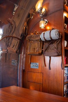 the interior of a boat with wooden walls and shelves on each side, including two backpacks