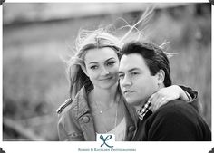 a man and woman are posing for a black and white photo with their hair blowing in the wind