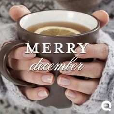 someone holding a cup of tea with the words merry december written in white on it