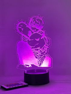 a purple light that is on top of a black stand with an image of two people