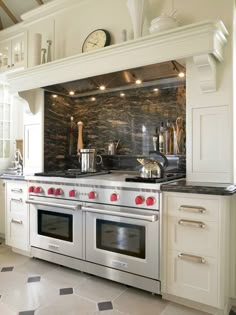 a kitchen with an oven, stove and counter top in the center is decorated with black and white tiles