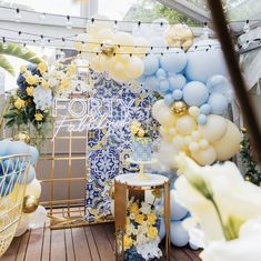 balloons and flowers are on display in a room that is decorated with blue, yellow and white