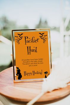 an orange sign that says don't say baby sitting on top of a wooden table