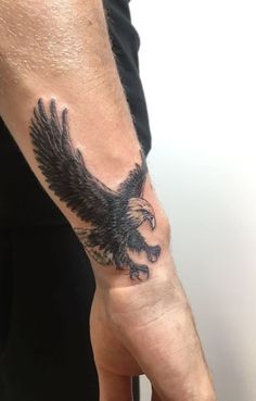 a man with a tattoo on his arm holding an eagle