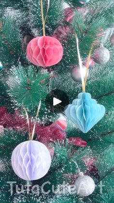 three paper ornaments hanging from the top of a christmas tree