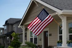 an american flag hanging from the side of a house