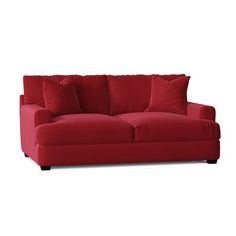 a red couch sitting on top of a white floor