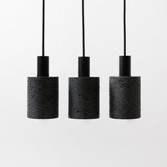 three black pendant lights hanging from the ceiling