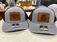 BULK ORDERS ONLY! Minimum Order Quantity is 12 hats with sewn-on leather patches with custom engraving. We sew on Genuine cow-hide leather patches on awesome snapback mesh back trucker hats for your business, farm, ranch, family reunion, promotional product, or company outing! Leather patches are laser engraved with your text or logo and then machine stitched onto the hat by us in our small factory in Iowa. See photo for stitch color options. All custom orders will receive a proof prior to produ Leather Hat With Curved Brim And Leather Patch, Leather Baseball Cap With Logo Patch And Flat Brim, Leather Baseball Cap With Curved Brim And Leather Patch, Leather Baseball Cap With Leather Patch, Leather Baseball Cap With Logo Patch, Leather Snapback Cap With Leather Patch, Flat Bill Leather Hat With Leather Patch, Casual Leather Trucker Hat With Flat Bill, Leather Flat Bill Hat With Leather Patch