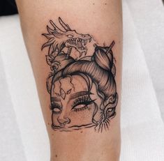 a woman's face with dragon and skull tattoos on her leg, as well as an eyeball