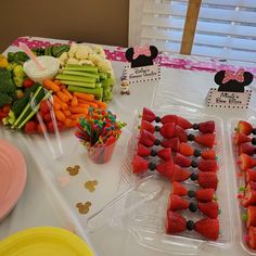 a table topped with lots of fruit and veggies on top of plastic trays