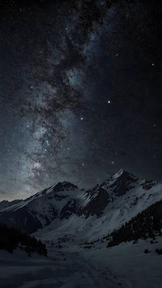 the night sky is filled with stars above snowy mountains and snow - capped peaks,