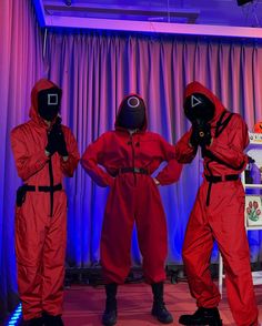 three people in red jumpsuits standing next to each other