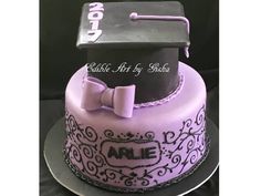 a graduation cake with purple frosting and a black hat on top that reads, edible art by sheila