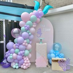 there is a large balloon arch with dolphin balloons on it