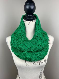 a green knitted scarf on top of a mannequin