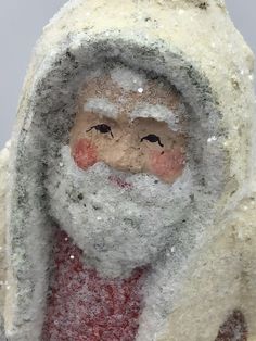 a close up of a santa claus figure with snow on it's face and beard