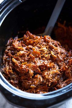 shredded meat in a crock pot with a spoon