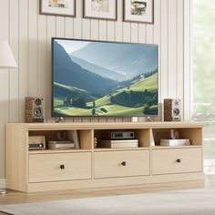 a flat screen tv sitting on top of a wooden entertainment center in a living room