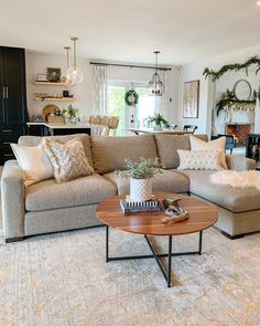 a living room filled with lots of furniture and decor on top of carpeted flooring