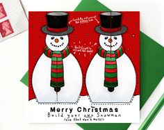 two snowmen wearing hats and scarves are standing next to each other on a christmas card