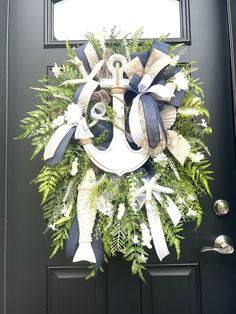 a wreath is hanging on the front door with an anchor and bow tie around it