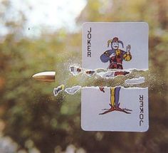 two playing cards floating in the air next to each other with trees in the background