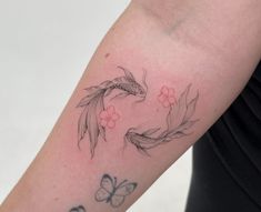 a woman's arm with two koi fish and flowers on the left side