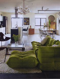 a living room filled with furniture and a chandelier hanging over the top of it